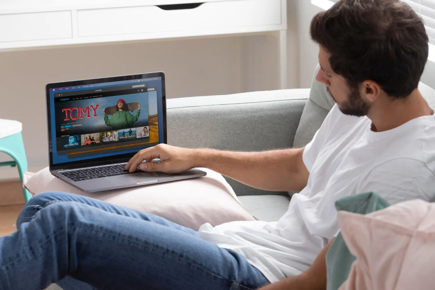 Mies testaa suomalaista IPTV:tä tabletilla kotona sohvalla