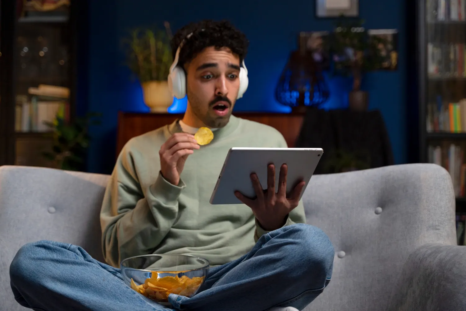 Mand ser IPTV på tablet derhjemme i sofaen